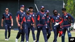 FILE - United States cricket players walk off the pitch after beating Singapore by 132 runs in a cricket World Cup qualifier match in Bulawayo, Zimbabwe, July 12, 2022.
