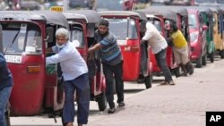 FILE - Auto rickshaw drivers line up to buy gas near a fuel station in Colombo, Sri Lanka, April 13, 2022. 