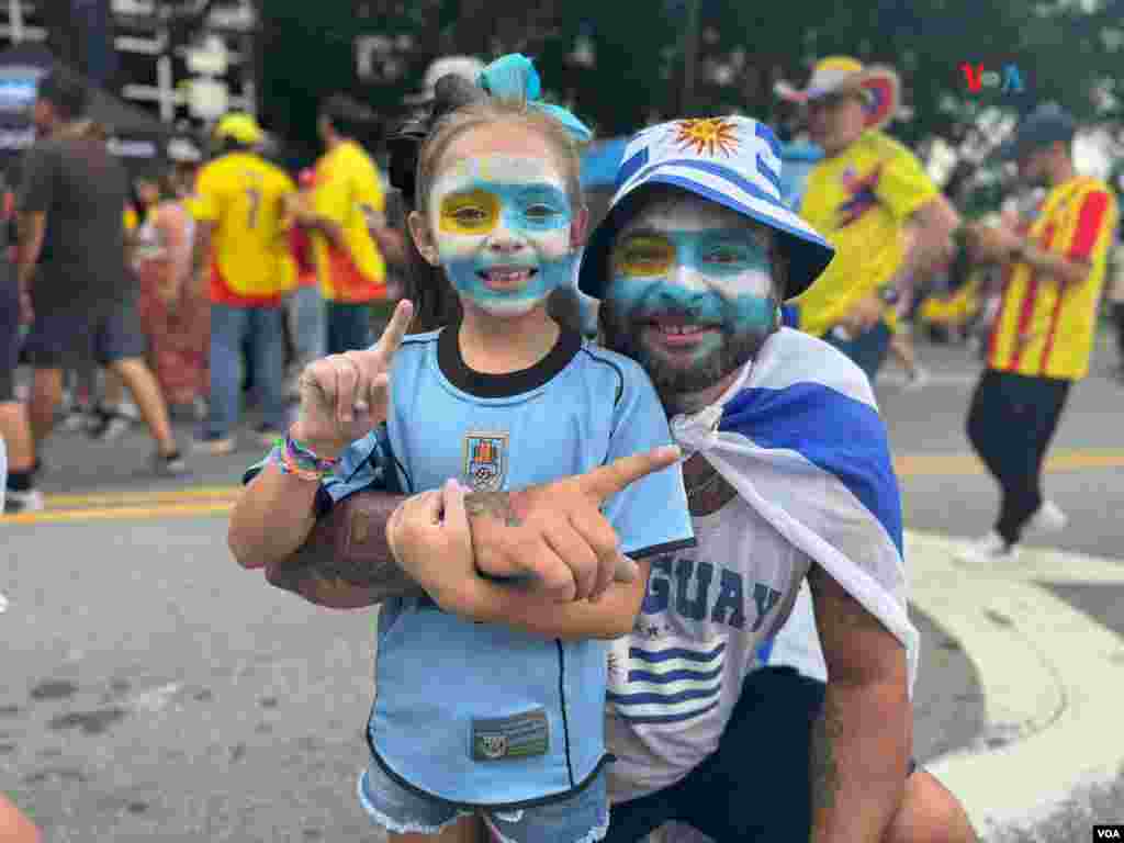 Uruguayos en Charlotte, Carolina del Norte, posan para foto mientras esperan el esperado juego entre Colombia y Uruguay el miércoles 7 de julio.