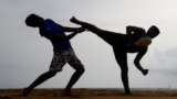 Two men perform martial arts on a beach in a suburb town of Colombo, Sri Lanka, July 2, 2023. 