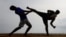 Two men perform martial arts on a beach in a suburb town of Colombo, Sri Lanka, July 2, 2023. 