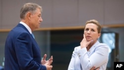 Denmark's Prime Minister Mette Frederiksen, right, speaks with Romania's President Klaus Werner Ioannis during a round table meeting at an EU summit in Brussels, June 29, 2023.