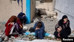2024年2月15日，由于以色列对加沙地带南部哈马斯武装分子的地面攻势，巴勒斯坦人从汗尤尼斯的纳赛尔医院撤离后抵达拉法，人们在受损的建筑物旁边休息。（路透社照片）