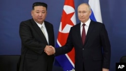 (FILE) Russian President Vladimir Putin, right, and North Korea's leader Kim Jong Un shake hands. 