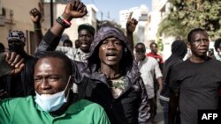 Protesters gesture after police fired tear gas at them outside the General Assembly in Dakar, Senegal, on Feb. 5, 2024.