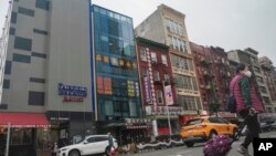 FILE - A six-story glass facade building, pictured second from left in New York's Chinatown, April 17, 2023, is believed to be the site of a foreign police outpost for China. On June 6, 2023, U.K. officials said China had closed similar stations across the nation. 