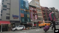 A six story glass facade building, pictured second from left in New York's Chinatown, April 17, 2023, is believed to be the site of a foreign police outpost for China.