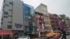 FILE — A six-story glass facade building, pictured second from left, in New York's Chinatown, April 17, 2023, is believed to be the site of a foreign police outpost for China.