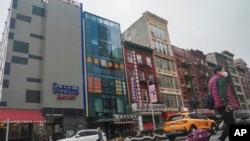 A six story glass facade building, pictured second from left in New York's Chinatown, April 17, 2023, is believed to be the site of a foreign police outpost for China.