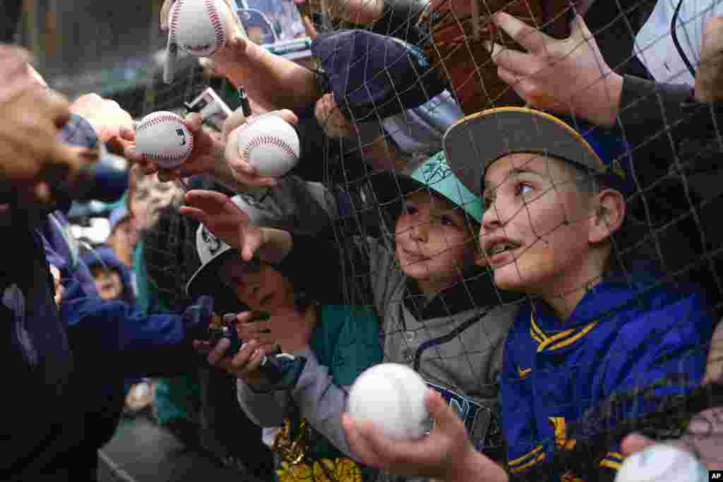 Fans try to get an autograph from Seattle Mariners center fielder Julio Rodríguez before a baseball game between the Mariners and the Cleveland Guardians, April 3, 2024, in Seattle, Washington.