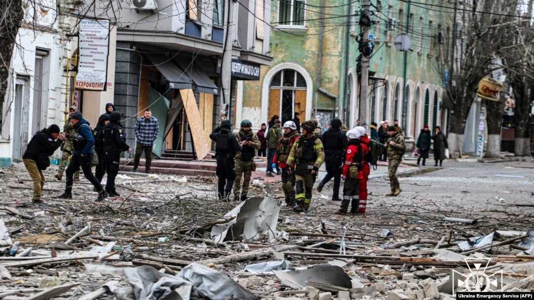 This handout photo taken and released by Ukrainian Emergency Service on Feb. 2, 2024, shows rescuers working outside a building damaged after an air strike on Kherson, Ukraine. (Ukrainian Emergency Service via AFP) 