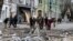 This handout photo taken and released by Ukrainian Emergency Service on Feb. 2, 2024, shows rescuers working outside a building damaged after an air strike on Kherson, Ukraine. (Ukrainian Emergency Service via AFP) 