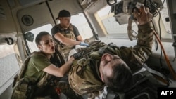 Ukrainian military paramedics evacuate a wounded serviceman from the front line near Bakhmut, March 23, 2023.