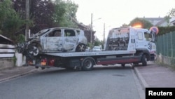 A burnt car is towed from the damaged residence of the Mayor of L'Hay-les-Roses, near Paris, France July 2, 2023.