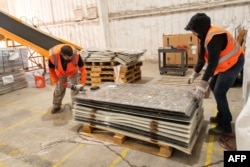 Workers dismantle solar panels to be recycled at the We Recycle Solar plant in Yuma, Arizona, Dec. 6, 2023. (Photo by VALERIE MACON / AFP)