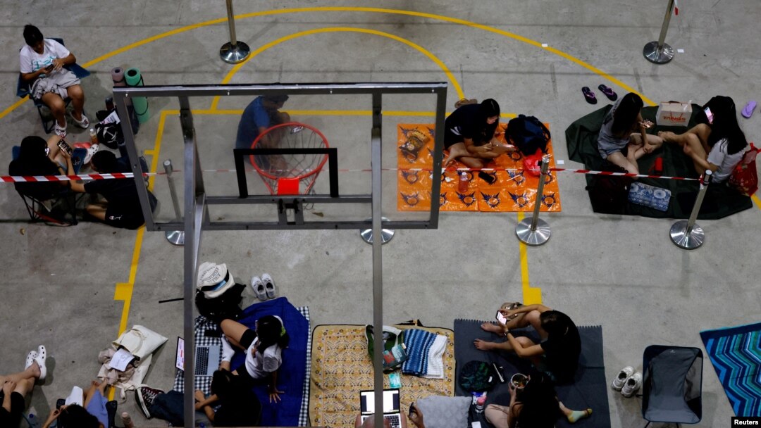 Orang-orang antre semalaman di lapangan basket pusat komunitas untuk mendapatkan tiket konser Taylor Swift, di luar kantor pos di Singapura, Singapura, 6 Juli 2023. (REUTERS/Edgar Su)