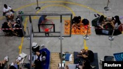 Orang-orang antre semalaman di lapangan basket pusat komunitas untuk mendapatkan tiket konser Taylor Swift, di luar kantor pos di Singapura, Singapura, 6 Juli 2023. (REUTERS/Edgar Su)