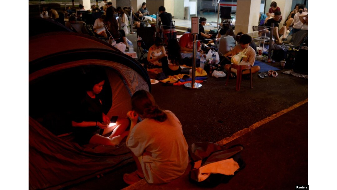 Sera (14), dan Eliza (14), bersiap tidur di tenda mereka saat mengantri semalaman untuk mendapatkan tiket konser Taylor Swift di luar kantor pos di Singapura, 6 Juli 2023. (REUTERS/Edgar Su)