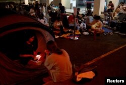 Sera (14), dan Eliza (14), bersiap tidur di tenda mereka saat mengantri semalaman untuk mendapatkan tiket konser Taylor Swift di luar kantor pos di Singapura, 6 Juli 2023. (REUTERS/Edgar Su)