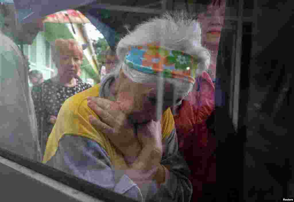 Local residents wait in a line for humanitarian aid after the Nova Kakhovka dam breached, in Kherson, Ukraine, June 11, 2023.