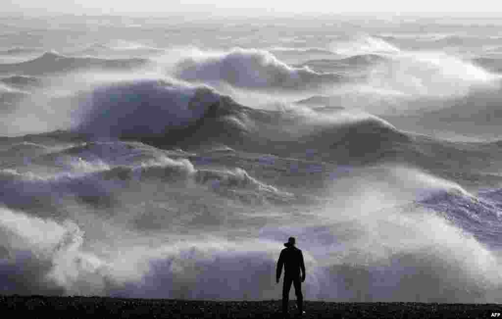 A person looks at the waves crashing on the shore in Newhaven, United Kingdom as Storm Henk was set to bring strong winds and heavy rain across much of southern England.