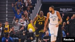 Draymond Green (23) de Golden State célèbre ses points derrière Rudy Gobert (27) de Minnesota, USA, le 12 novembre 2023. 