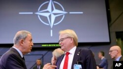 FILE - Turkish Defense Minister Hulusi Akar, left, speaks with Sweden's Defense Minister Peter Hultqvist during a meeting of the North Atlantic Council in defense ministers format at NATO headquarters in Brussels, Oct. 13, 2022.