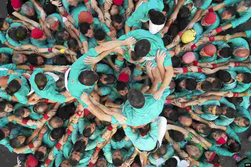 Anggota tim Menara Manusia &quot;Castellers de Villafranca&quot; membentuk &quot;castell&quot; dalam pameran untuk merayakan ulang tahun ke-75 yayasan mereka di alun-alun Zocalo, Mexico City, 21 November 2023.