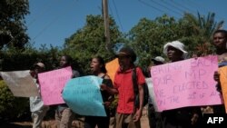 Party supporters hold placards as they protest outside the home of recalled Member of Parliament for Mabvuku-Tafara constituency, Munyaradzi Kufahakutizwi of the Citizens Coalition for Change (CCC) opposition party, in Harare on December 9, 2023