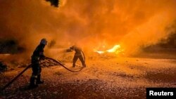 ইউক্রেনের ওডেসা অঞ্চলে এক বন্দরে উদ্ধারকর্মীরা ট্রাকের আগুন নেভাতে ব্যস্ত। ২৬ সেপ্টেম্বর, ২০২৩। রয়টার্স।