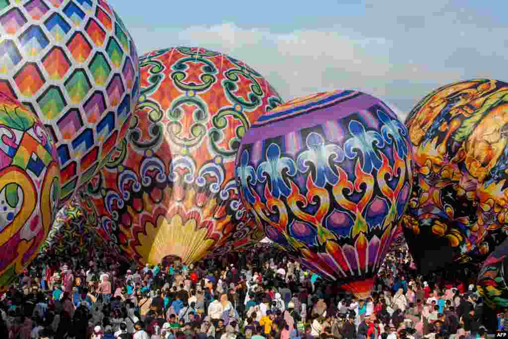 Para peserta bersiap menerbangkan balon udara dalam festival balon udara tradisional di Wonosobo, Jawa Tengah, selama perayaan hari raya Idul Fitri. (Devi Rahman/AFP)