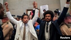 Tennessee state lawmakers Justin Pearson and Justin Jones raise their hands after being expelled from their seats in Nashville, Tennessee, April 6, 2023.