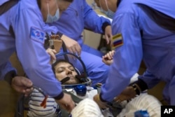 FILE - Russian Space Agency experts test a space suit of Russian cosmonaut Oleg Kononenko, ahead of a launch at the Russian leased Baikonur Cosmodrome, in Kazakhstan, Wednesday, July 22, 2015. (AP Photo/Pavel Golovkin, File)