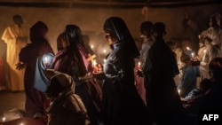 Worshippers of the Legio Maria African Church Mission gather to pray during the Christmas Eve vigil mass in a church near Ugunja, on December 24, 2023.