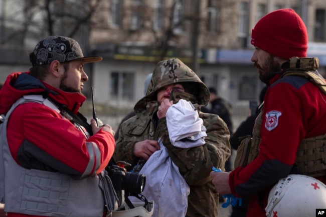 A wounded resident talks with paramedics after Russia's missile attack in Kyiv, Ukraine, Dec. 29, 2023.