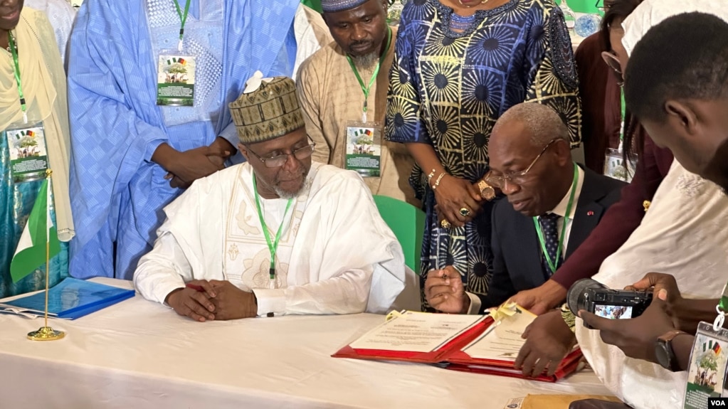 Nigeria's environment minister, Balarbe Abbas Lawal, seated at left, and his Cameroonian counterpart, Jules Doret Ndongo, are pictured at the signing of a transborder agreement to protect wildlife, in Abuja, Nigeria, April 19, 2024. (Timothy Obiezu/VOA)