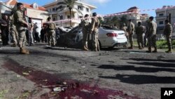 Lebanese army soldiers gather around a damaged car near the coastal town of Jadra, south Lebanon, Feb. 10, 2024.