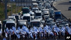 FILE - Israeli protesters block the Tel Aviv-Haifa highway near Beit Yanai, Israel, during a protest against plans by Prime Minister Benjamin Netanyahu's new government to overhaul the judicial system, July 11, 2023. 