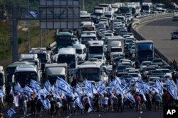 Paranpengunjuk rasa memblokir jalan raya Tel Aviv-Haifa dekat Beit Yanai, Israel, selama protes terhadap rencana pemerintah baru Perdana Menteri Benjamin Netanyahu untuk merombak sistem peradilan, 11 Juli 2023. (Foto: AP)