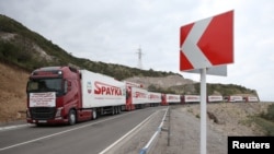 2023 年 9 月 23 日，为纳戈尔诺-卡拉巴赫居民运送人道主义援助物资的卡车在亚美尼亚科尔尼佐尔村附近的道路上驶向亚美尼亚-阿塞拜疆边境。