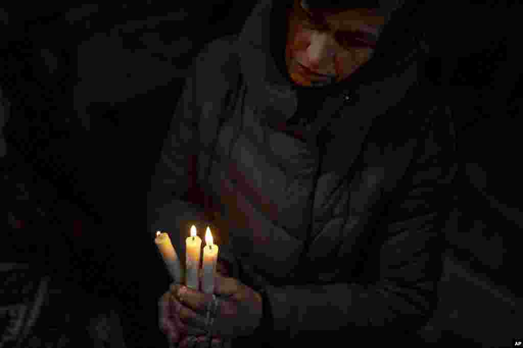 Una mujer reza en el interior de una iglesia durante la celebración de la Navidad, en Kryvorivnia, Ucrania, el 24 de diciembre de 2023. (AP Foto/Evgeniy Maloletka).