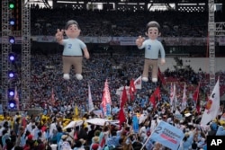 Balon calon Presiden Prabowo Subianto, kiri, dan pasangannya Gibran Rakabuming Raka, putra sulung Presiden Joko Widodo, dipajang saat kampanye di Stadion Utama Gelora Bung Karno di Jakarta, 10 Februari 2024. (Foto: AP)