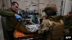 FILE - Ukrainian military medics treat a wounded Ukrainian serviceman at a stabilisation point near Bakhmut, Donetsk region, on Feb. 9, 2024,