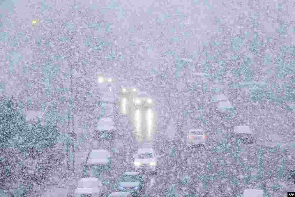 Cars make their way during snowfall in Dalian, in China&#39;s northeastern Liaoning province.