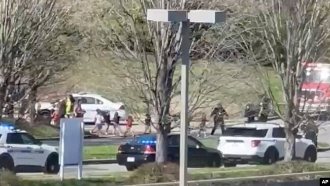 Law enforcement officers lead children away from the scene of a shooting at The Covenant School, a private Christian school in Nashville, Tennessee, on March 27, 2023, in this this image from video provided by Jozen Reodica.