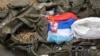 (FILE) A Serbian flag is displayed along weapons and military equipment seized during the Kosovo police operation.