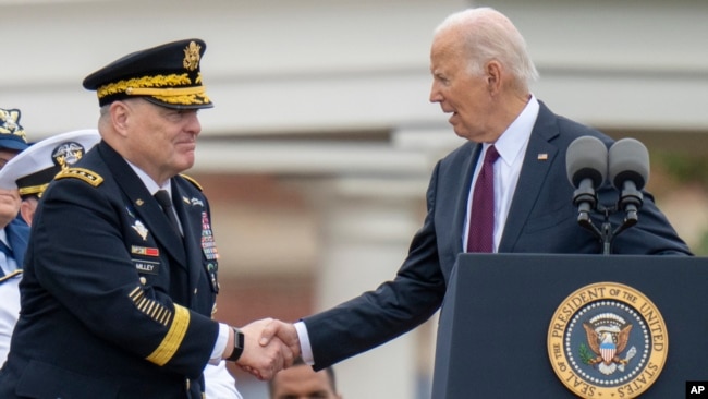 FILE - President Joe Biden shakes hands with outgoing Joint Chiefs Chairman Gen. Mark Milley, during an Armed Forces Farewell Tribute in honor of Milley at Joint Base Myer–Henderson Hall, Sept. 29, 2023, in Fort Myer, Va.