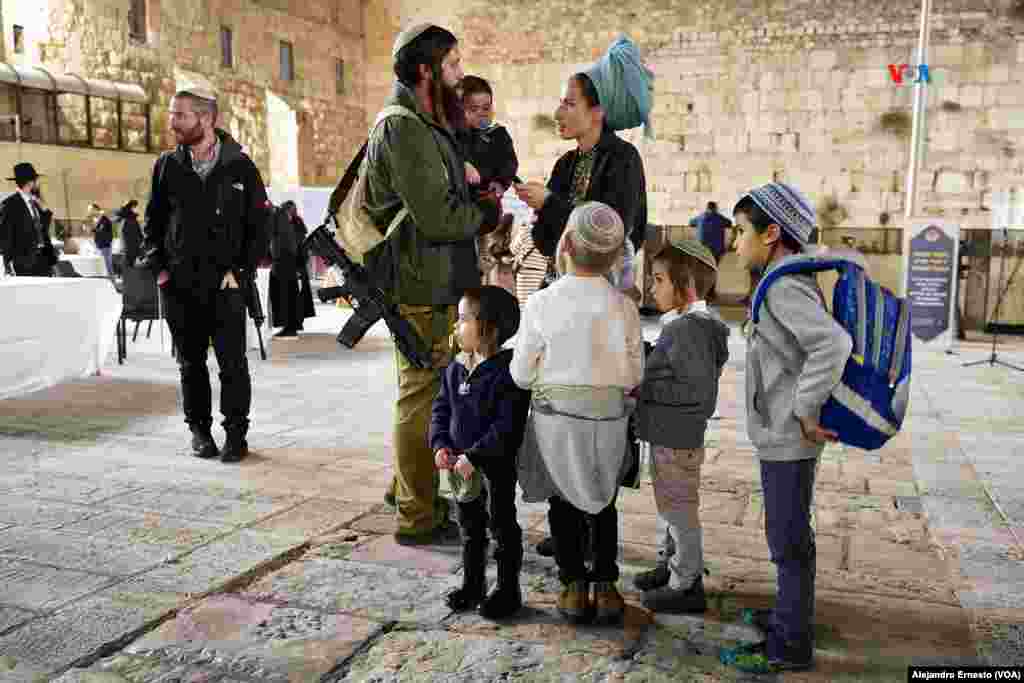 Una familia judía asiste en el Muro de las Lamentaciones de Jerusalén a la ceremonia de homenaje y recordación a los caídos en la guerra entre Israel y Hamás.