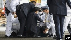 A suspect is caught by police after he allegedly threw an object, as Japanese Prime Minister Fumio Kishida visited a campaign event in Wakayama, Japan, April 15, 2023.