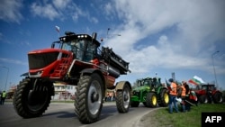 Farmers drive their tractors during an action to block trucks crossing the Danube bridge, marking the border between Bulgaria and Romania in a protest against the duty-free import of grain coming from Ukraine into the EU, in Rousse, Bulgaria, on March 29, 2023. 